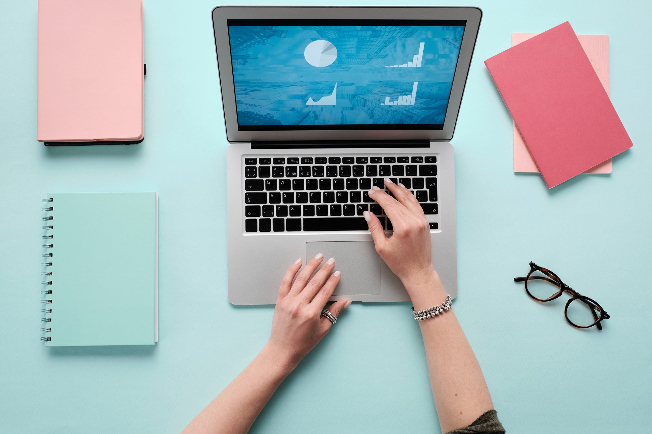 A Person Using a Laptop on Teal Table